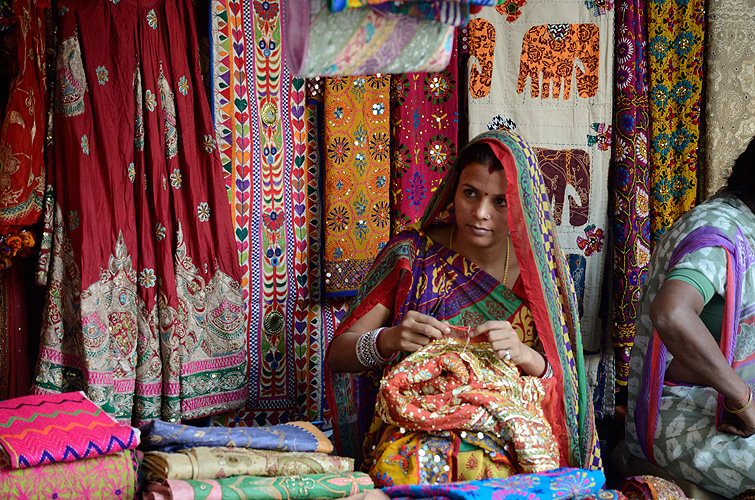 Eine Näherin verkauft farbenprächtige Stoffe in traditionellem Design