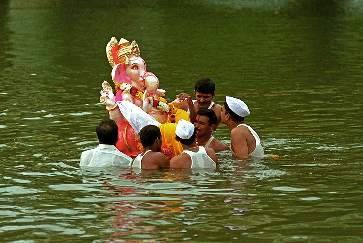 Junge Männer tragen Ganesh-Statue in den Fluss, Pune